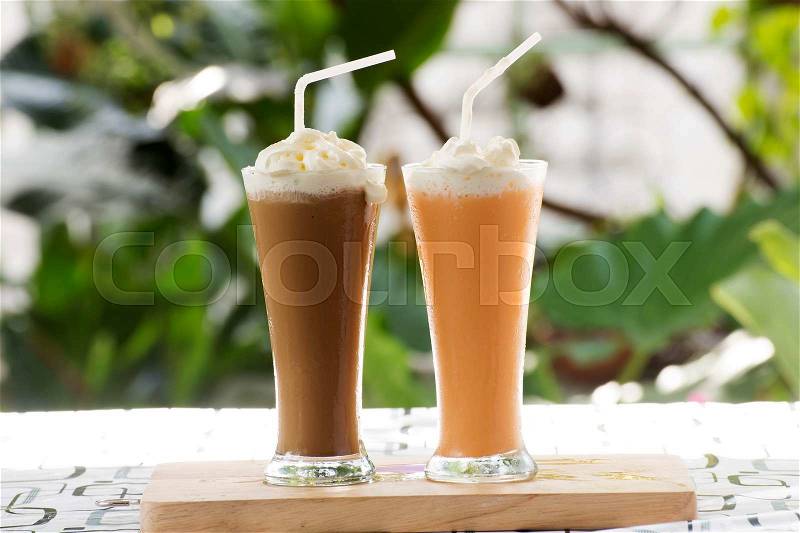 Glass of Thai Coffee and Tea smoothie topping with whip cream, stock photo