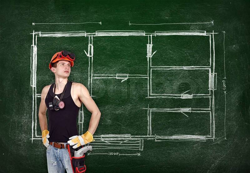 Repairman with drill and drawing plan apartment on blackboard, stock photo