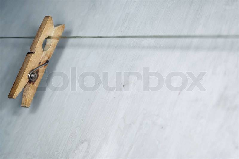 Close-up horizontal photo of the old wooden clothes pin hanged on a clothes-line, stock photo