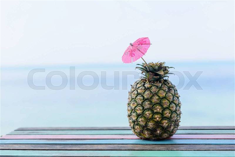 Pineapple fruit on vintage wood floor with seascape background, stock photo
