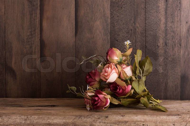 Vintage rose bouquet on grunge wood background, stock photo