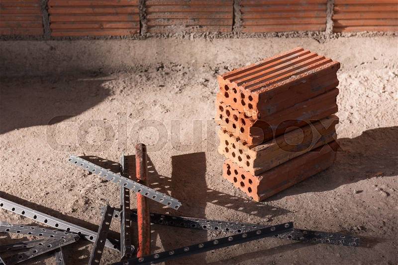 Red bricks and tool at construction site, stock photo