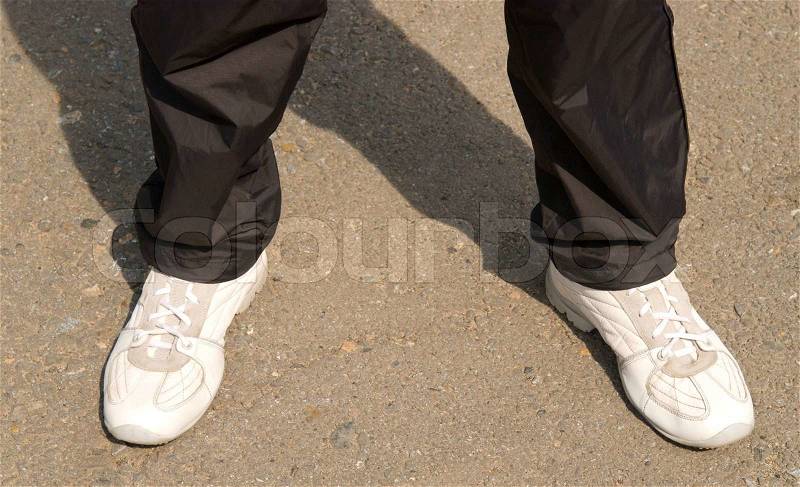Man in sports footwear has stopped on asphalt, stock photo