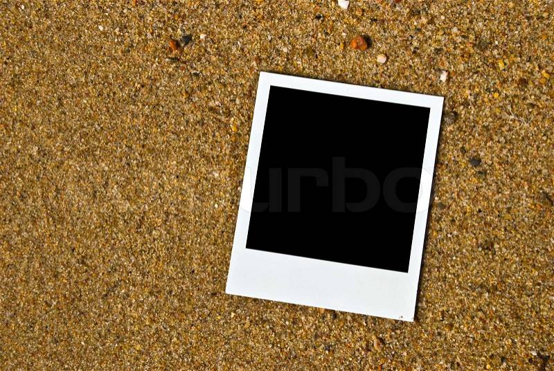 Photo frame on sand background, stock photo