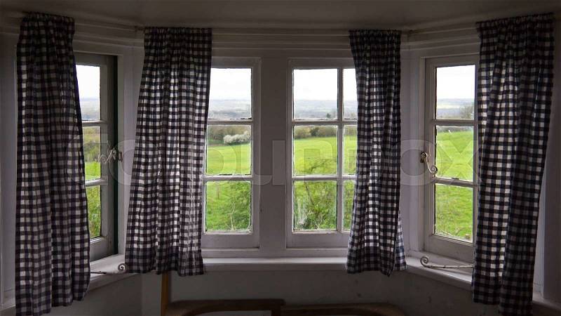 Rustic windows with curtains with view of countryside, stock photo