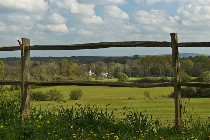 Scenic rural landscape featuring lush farmland and fence in Surrey, England, stock photo