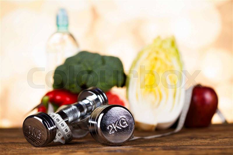 Health and fitness concept with dumbbells, measure tape and fresh fruit, stock photo
