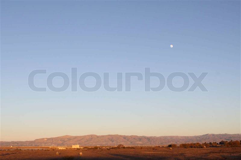 Evening lanscape with mountains on the horizon and the Moon, stock photo