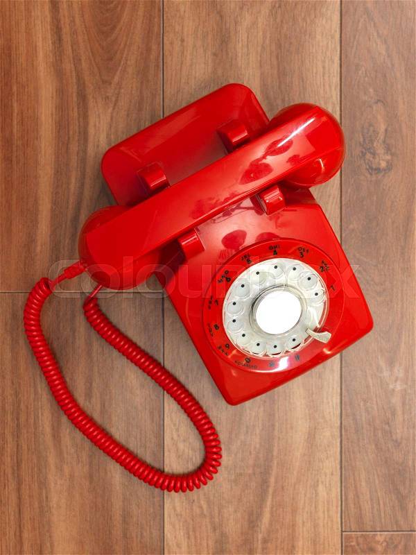 A close up photo of a red rotary phone, stock photo
