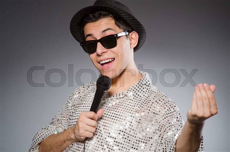 Young man in silver shirt and microphone isolated on white, stock photo