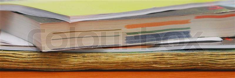Pile of old magazines on table (wood background), stock photo