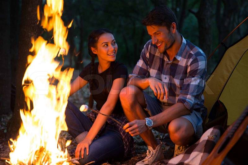 Couple fried sausages on bonfire in the forest , stock photo