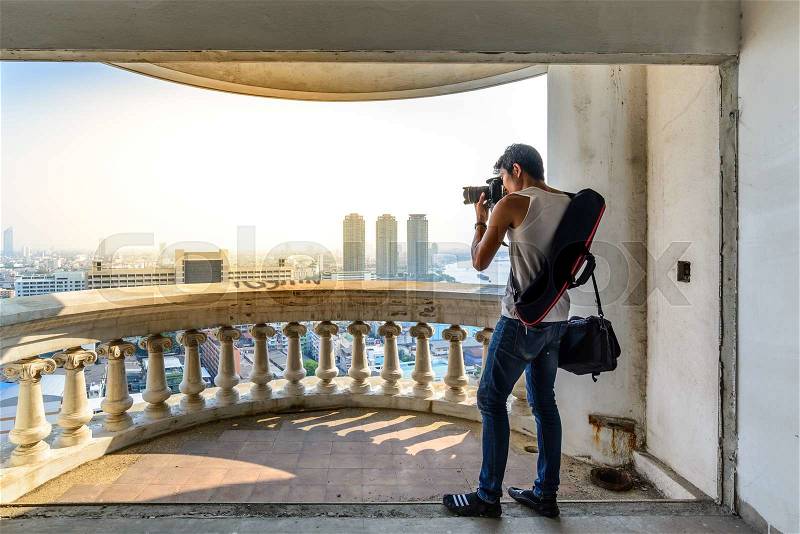 Men photographer standing and shooting cityscape view from aerial view in bangkok, stock photo