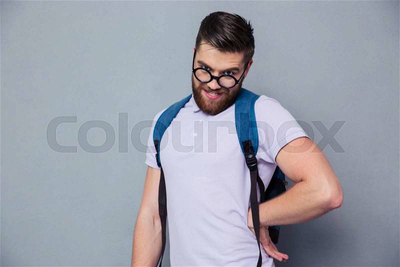 Portrait of a male nerd with funny face standing over gray background, stock photo