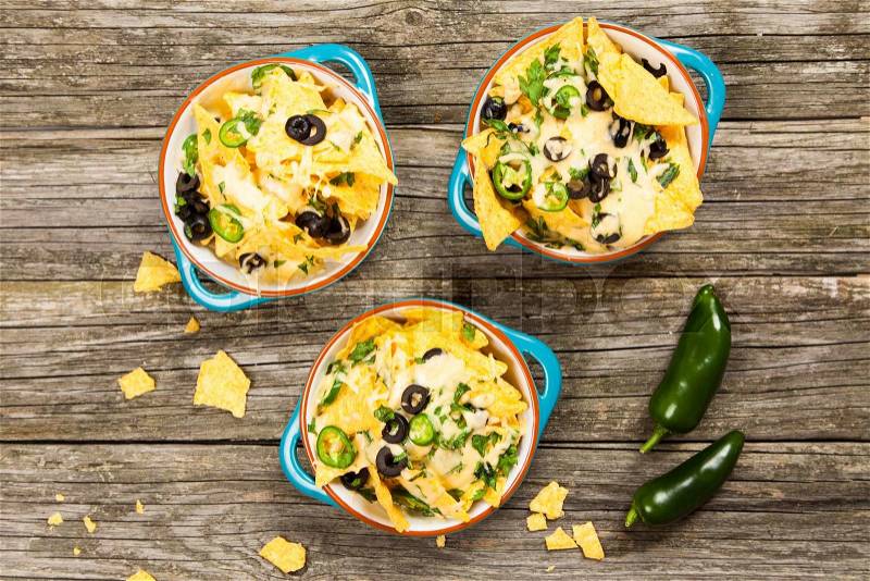 Nachos with melted cheese and salsa, guacamole and cheese dips, stock photo