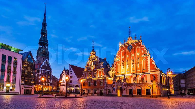 Panorama of Riga Town Hall Square, House of the Blackheads, St. Roland Statue and St. Peter\'s Church illuminated in the twilight, Riga, Latvia, stock photo