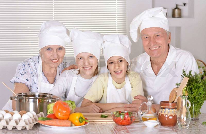 Portrait of a happy family cooking together with grandchildren, stock photo