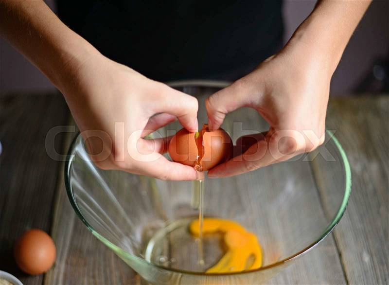 Close-up picture of hands broking eggs. , stock photo