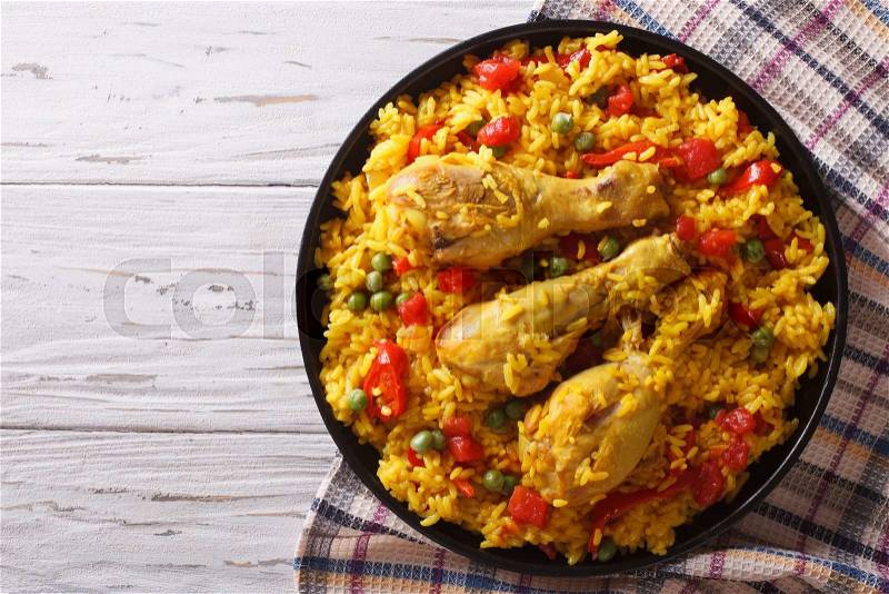 Spanish paella with chicken and vegetables on a plate. horizontal view from above , stock photo
