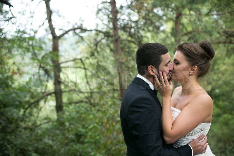 Bride and groom dancing the first dance together in the woods, stock photo