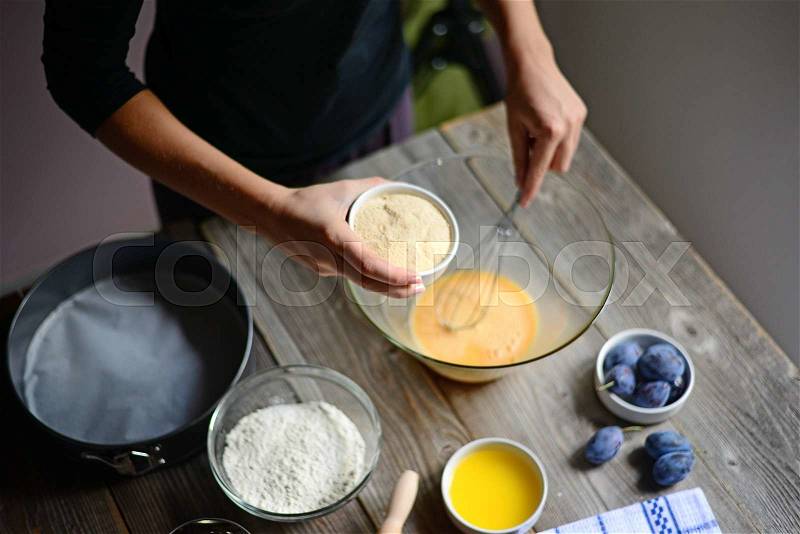 Baking: Woman prepare the eggs for butter and flour, and finally will make plum cake, stock photo