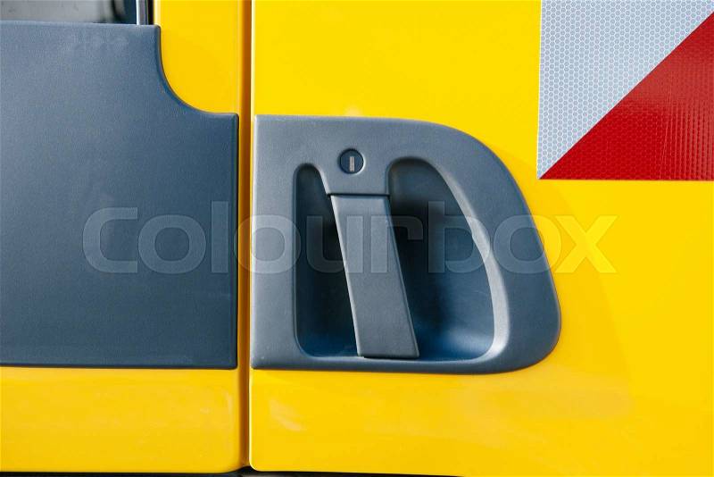 Plastic truck door handle of a yellow truck, stock photo