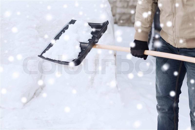 Transportation, winter, people and vehicle concept - closeup of man digging snow with shovel near car, stock photo
