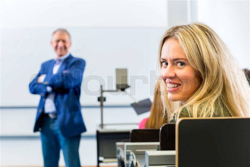Students listening to college professor giving lecture , stock photo