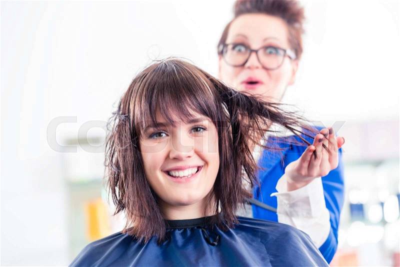 Female coiffeur blow dry women hair with blow dryer in shop, stock photo