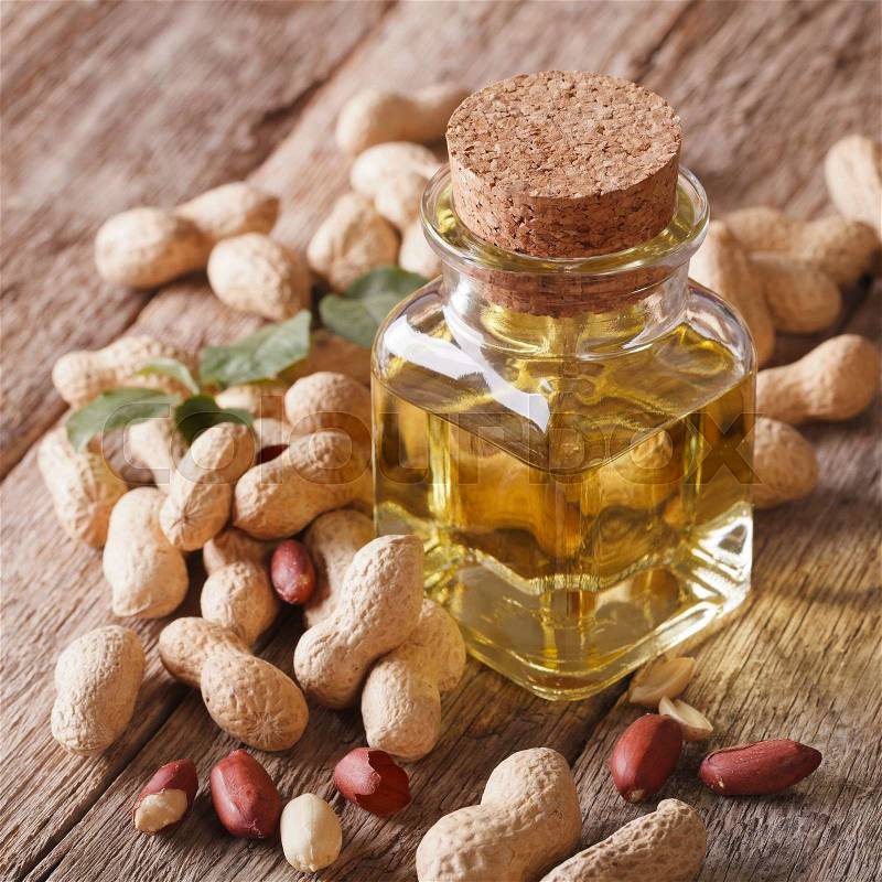 Aromatic natural peanut oil in a glass jar close up on the table, rustic , stock photo