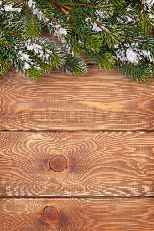 Christmas fir tree with snow on rustic wooden board with copy space, stock photo