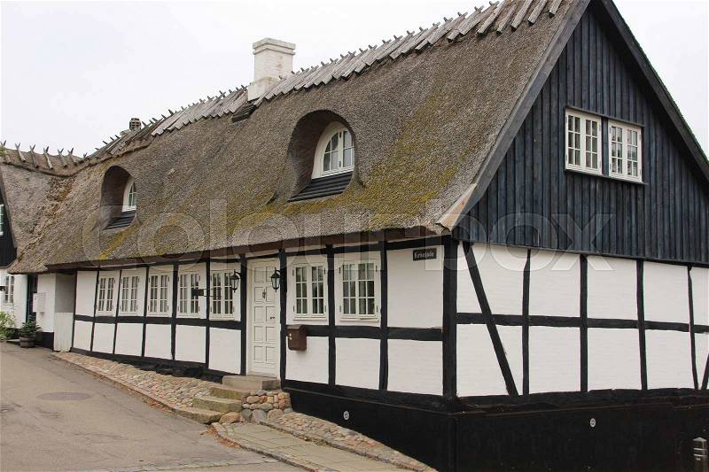 An ancient house with roofing material, reed, in the residential area in the city Roskilde in Denmark in the summer, stock photo