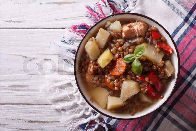 Homemade soup of brown lentils with chicken and vegetables close-up on the table. top view horizontal , stock photo