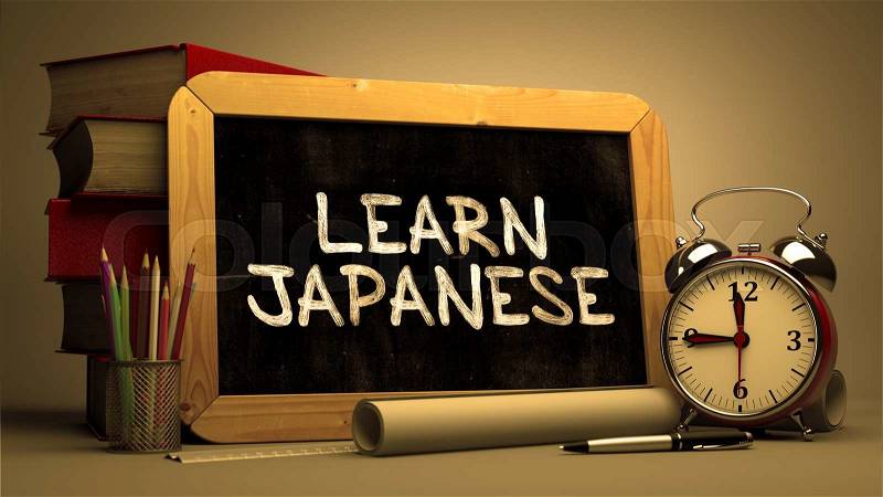 Learn Japanese Handwritten by white Chalk on a Blackboard. Composition with Small Chalkboard and Stack of Books, Alarm Clock and Rolls of Paper on Blurred Background. Toned Image, stock photo