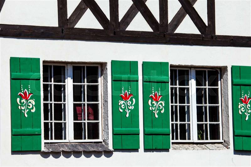 Typical germany windows with green shutters and window box , stock photo