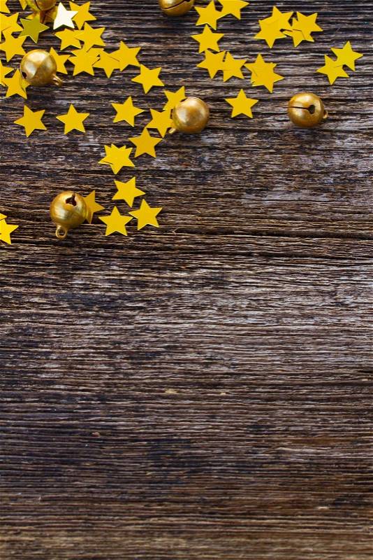 Christmas shiny golden stars decorations on aged wooden background, stock photo