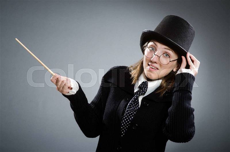 Harry Potter girl with magic stick against gray, stock photo