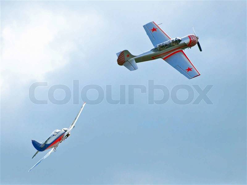 Two small airplanes in the cloudy sky, stock photo