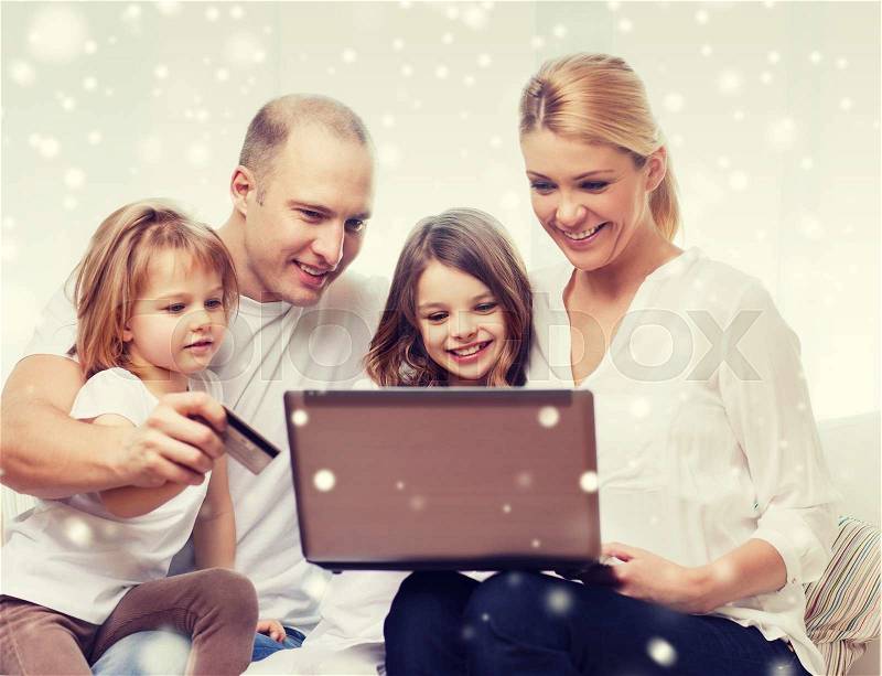 Family, shopping, technology and people concept - happy family with laptop computer and credit card over snowflakes background, stock photo