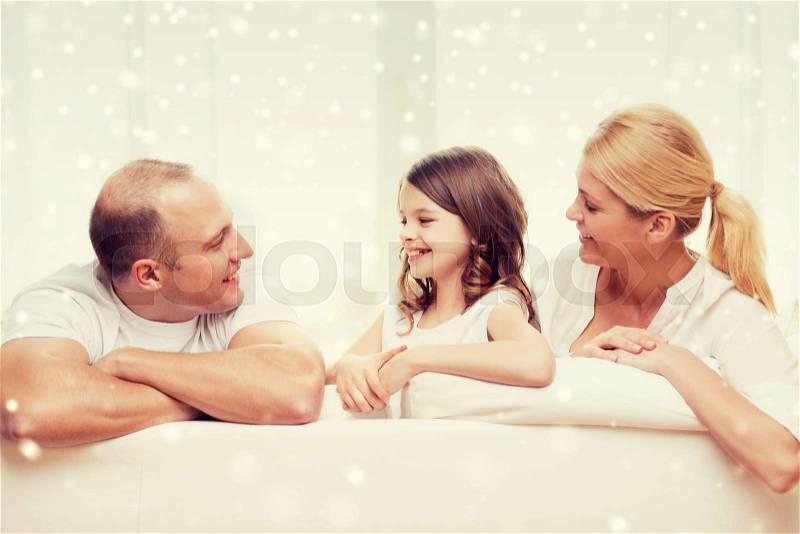 Family, childhood, communication, people and home concept - smiling parents with little girl talking at home, stock photo