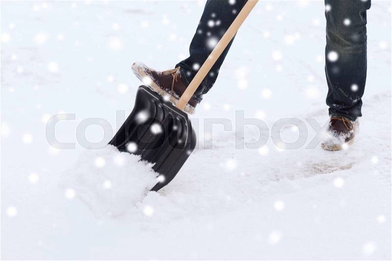 Transportation, winter, people and vehicle concept - closeup of man digging snow with shovel, stock photo