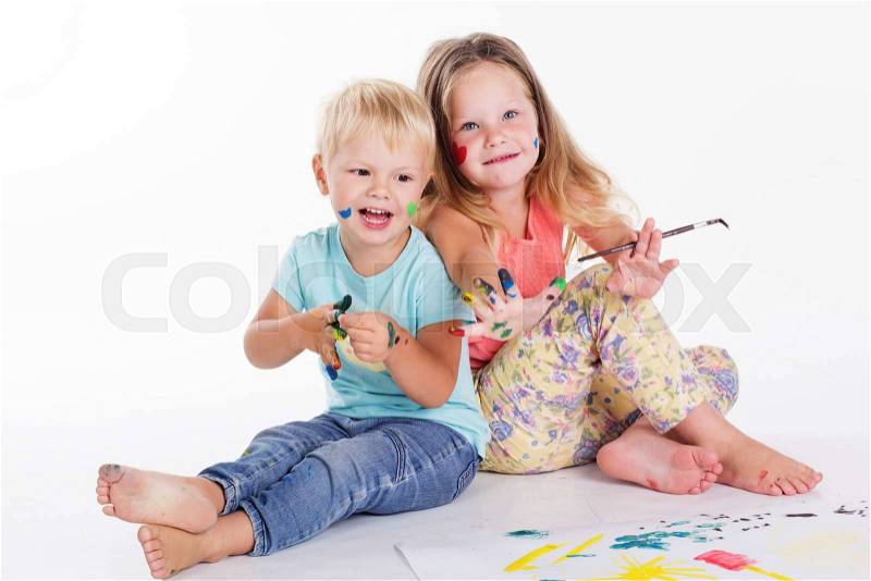 Two happy boy and girl are having fun and drawing pictures by aquarelle paints, stock photo