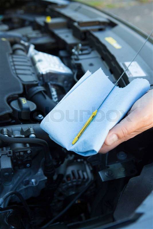 Close-Up Of Man Checking Car Engine Oil Level On Dipstick, stock photo