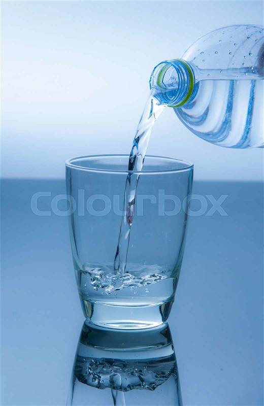 Water poured from a bottle into a glass, stock photo