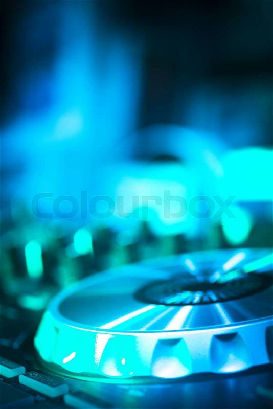 DJ console cd mp4 deejay mixing desk Ibiza house techno dance music wedding reception party in nightclub with colored lighting effect disco lights, stock photo