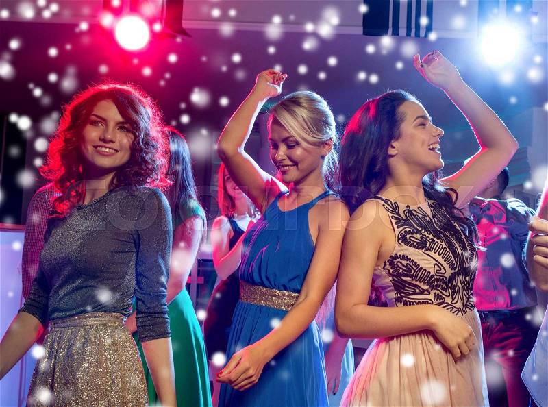Party, holidays, celebration, nightlife and people concept - smiling friends dancing in club, stock photo