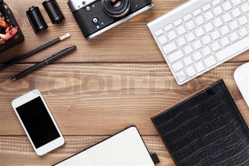 Office desk table with computer, supplies and camera. Top view with copy space, stock photo