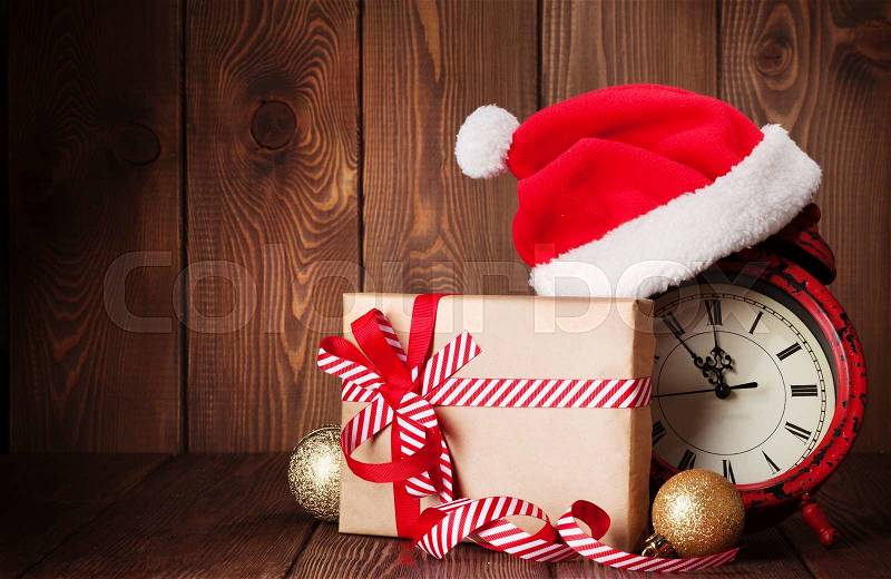 Christmas gift box, alarm clock and santa hat. View with copy space, stock photo