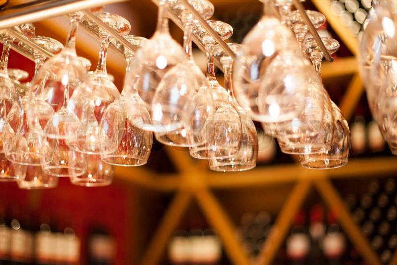 Empty glasses for wine above a bar rack , stock photo