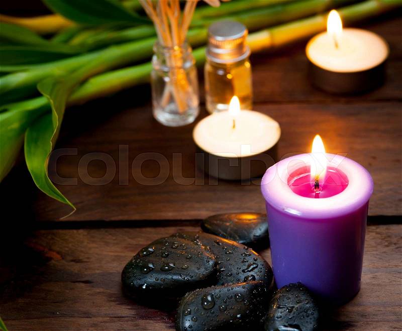 Zen basalt stones, lavender candles on wooden,dark background,,Selective focus on candle, stock photo